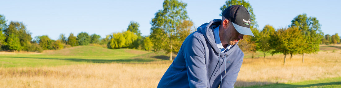 a golfer showcasing a sweater available in a golf bundle box
