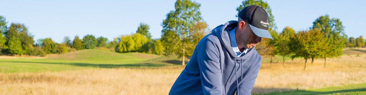 a golfer showcasing a sweater available in a golf bundle box